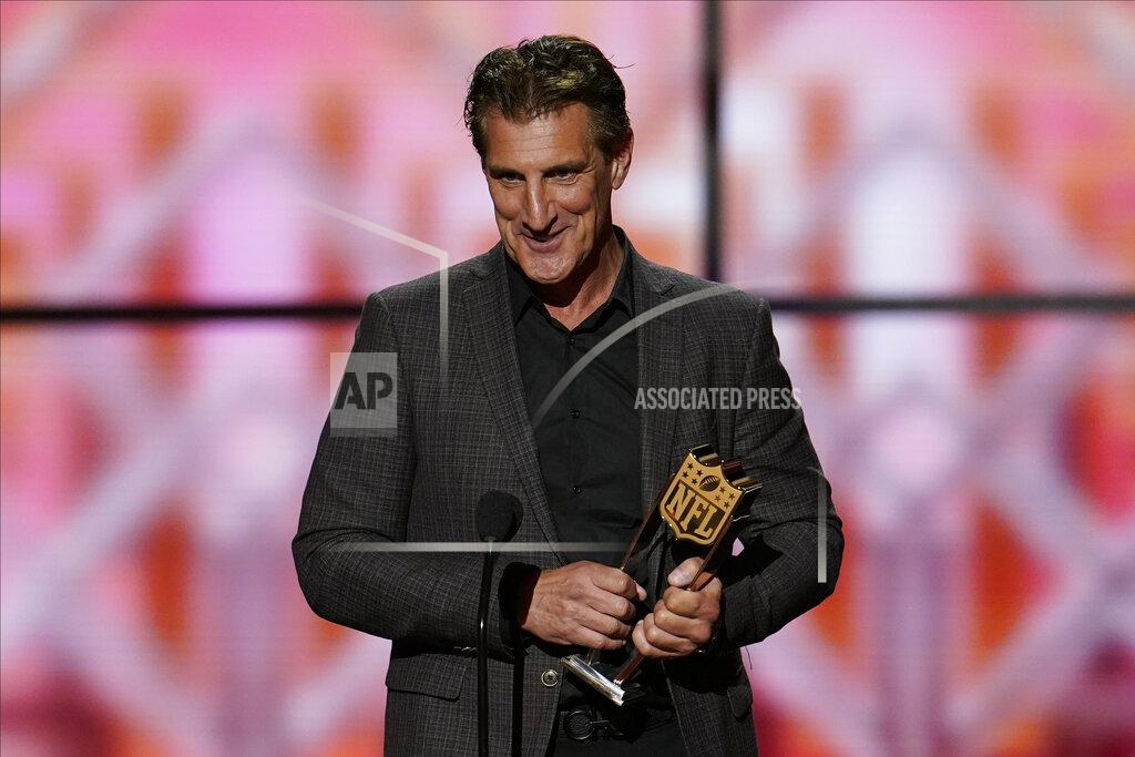 David J. Phillip CORRECTS TO NFL DEFENSIVE ROOKIE, NOT DEFENSIVE PLAYER - John Bosa accepts the AP Defensive Rookie of the Year award for is son San Francisco 49ers' Nick Bosa at the NFL Honors football award show Saturday, Feb. 1, 2020, in Miami. (AP Photo/David J. Phillip)