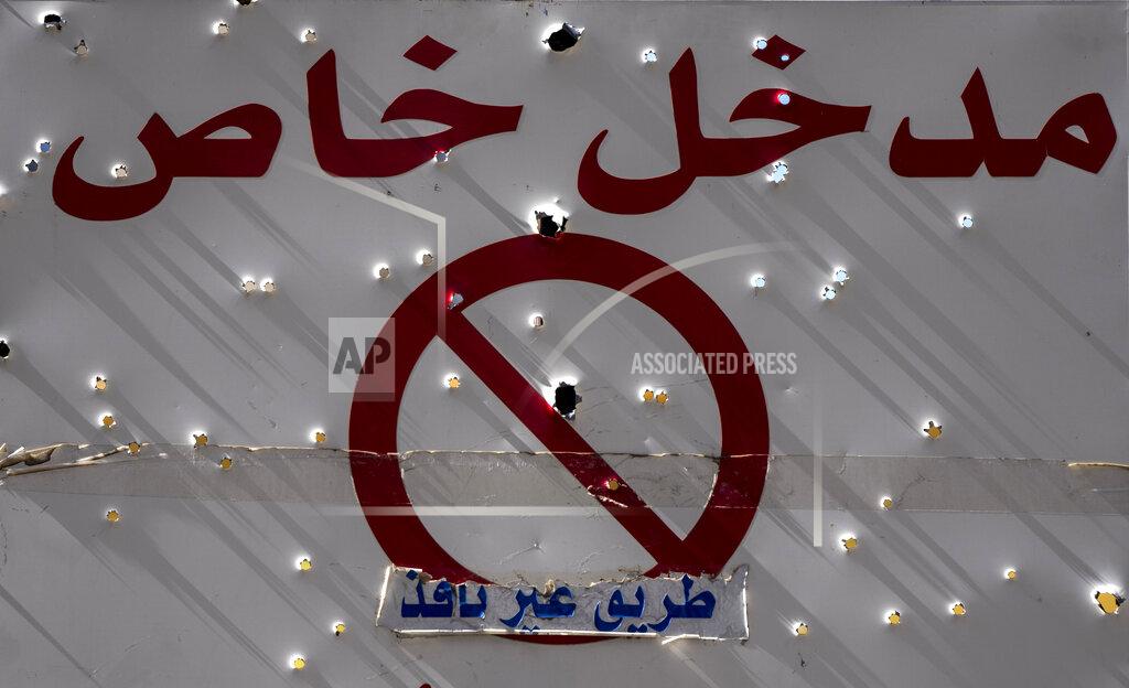 Hassan Ammar A sign with Arabic that read: "Private entrance, Dead end," is riddled with bullet holes after the deadly clashes that erupted last Thursday along a former 1975-90 civil war front-line between Muslim Shiite and Christian areas, in Ain el-Rumaneh neighborhood, Beirut,Lebanon, Tuesday, Oct. 19, 2021. The shootout on the streets of Beirut between rival Christian and Muslim groups has revived memories of the country's 1975-90 civil war and fired up sectarian passions in a country that never dealt with the causes of its violent past. (AP Photo/Hassan Ammar)