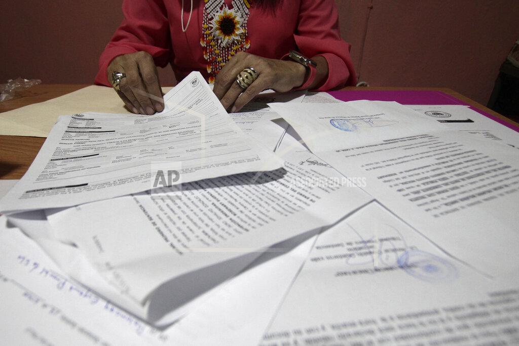 Salvador Melendez A Salvadoran businesswoman, who is one of the applicants of a small refugee program that was shut down by President Donald Trump, shows documents of the many times she has reported robberies and extortions, in Santa Ana, El Salvador, Saturday, Aug. 22, 2020. She said she was terrified when she began receiving death threats in 2013. Men with tattoos would come to a car wash she used to own to demand "monthly compensation" for letting her operate. She says she has received many threats since — through calls, text messages and social media. (AP Photo/Salvador Melendez)
