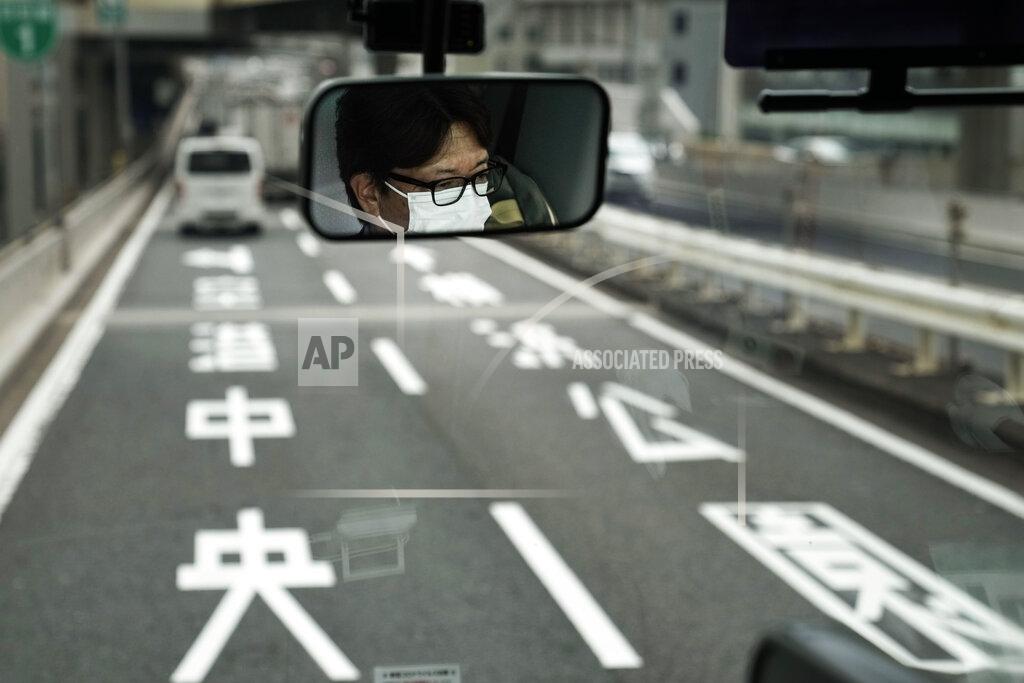 Jae C. Hong A bus driver is reflected in the mirror, Tuesday, July 13, 2021, in Tokyo. (AP Photo/Jae C. Hong)
