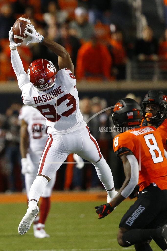 Sue Ogrocki Oklahoma wide receiver Nick Basquine (83) jumps up to catch a pass in front of Oklahoma State cornerback Rodarius Williams (8) in the first half of an NCAA college football game in Stillwater, Okla., Saturday, Nov. 30, 2019. (AP Photo/Sue Ogrocki)