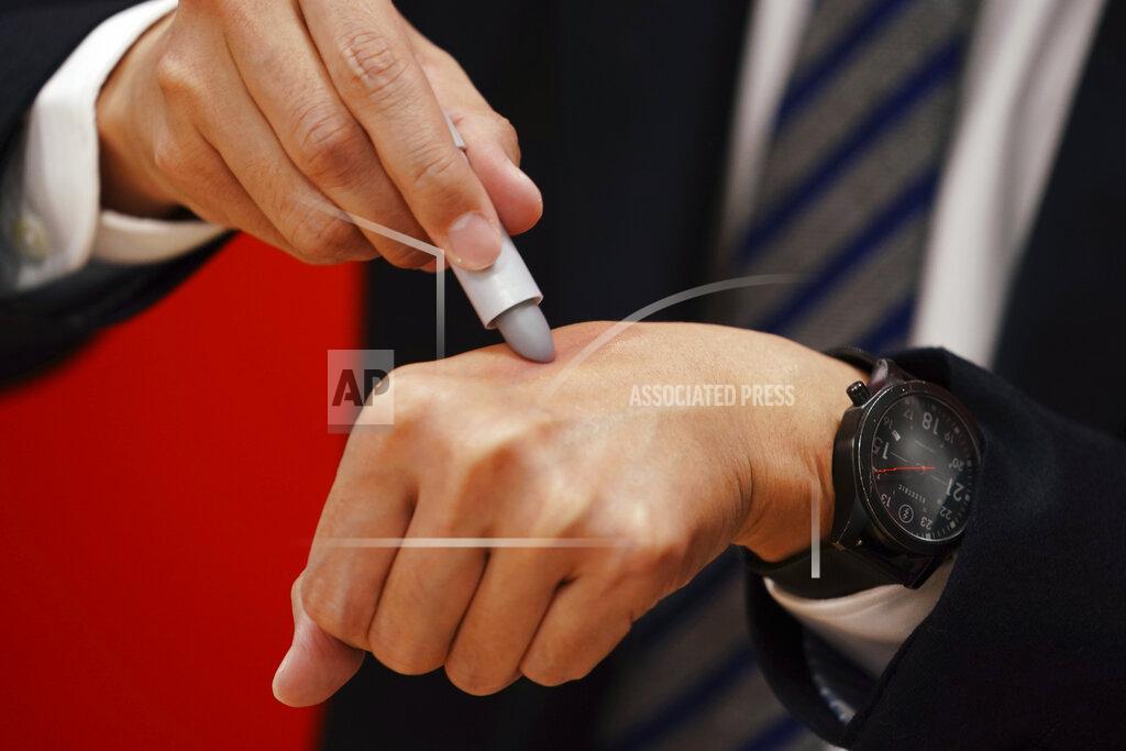 Eugene Hoshiko Yoshiyuki Matsuo, assistant brand manager of uno Group of Shiseido Japan Co., Ltd, a Japanese multinational cosmetic and personal care brand, shows the brand's latest lip balm for men, colored in grey, but the color turns red when it touches skins, in Tokyo Thursday, April 15, 2021. A large personal care company, Shiseido, says one of its male makeup lines has seen double-digit growth during the coronavirus pandemic. Company officials give a similar reason: Men, confronted with the sight of their faces repeatedly during online meetings, want to improve what they see. (AP Photo/Eugene Hoshiko)