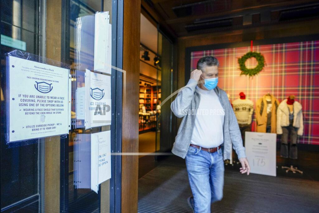 Mary Altaffer A Black Friday shopper adjusts his face mask as he leaves the Abercrombie & Fitch store along Fifth Avenue, Friday, Nov. 27, 2020, in New York. (AP Photo/Mary Altaffer)