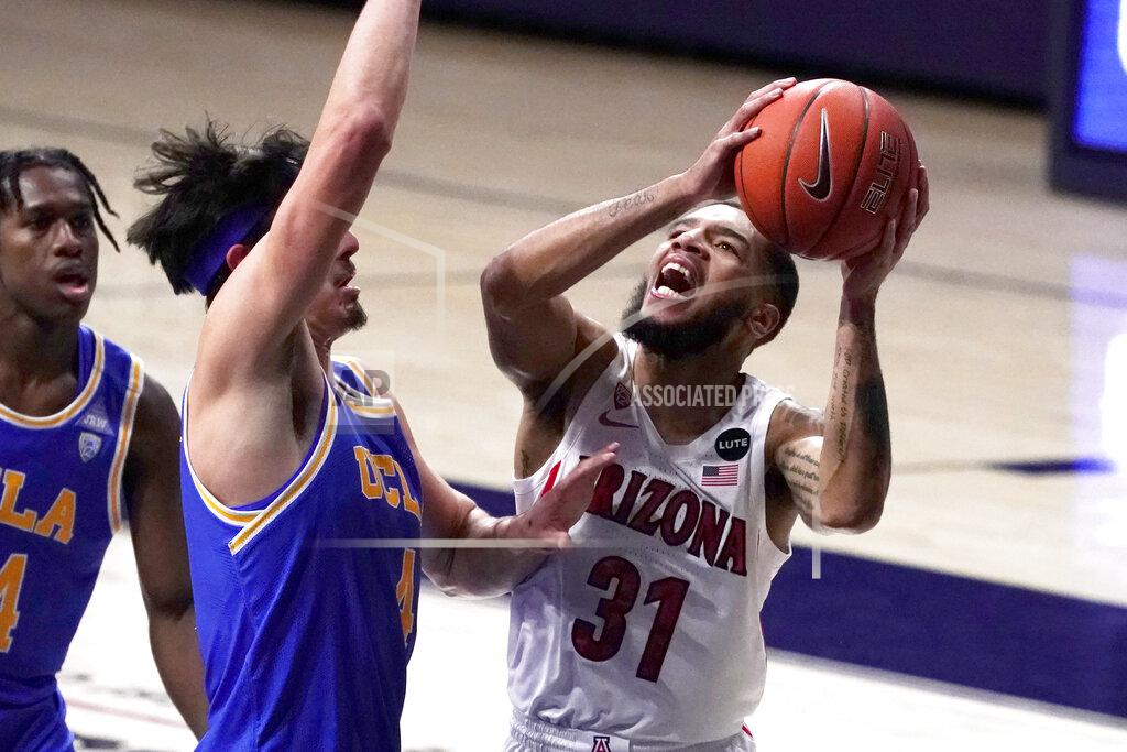 Rick Scuteri Arizona guard Terrell Brown Jr. (31) shoots in front of UCLA guard Jaime Jaquez Jr. during the first half of an NCAA college basketball game Saturday, Jan. 9, 2021, in Tucson, Ariz. (AP Photo/Rick Scuteri)