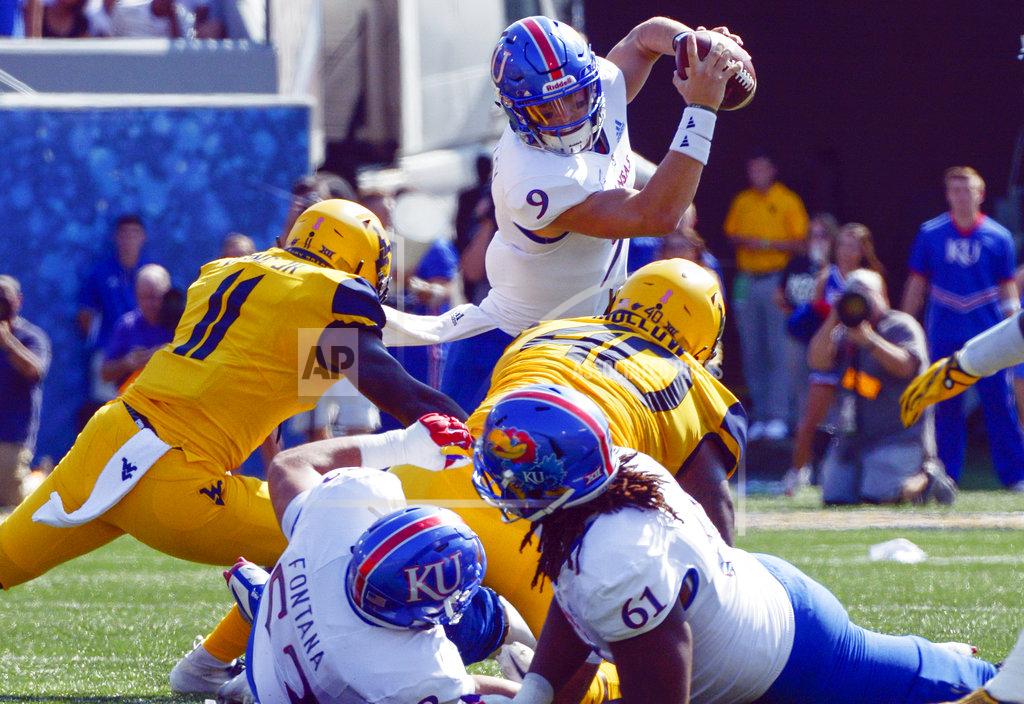 Craig Hudson Kansas quarterback Carter Stanley (9) is tackled by West Virginia linebackers David Long Jr. (11) and Kenny Bigelow, Jr. during the first half of an NCAA college football game against Kansas in Morgantown, W. Va., Saturday Oct. 6, 2018. (Craig Hudson/Charleston Gazette-Mail via AP)