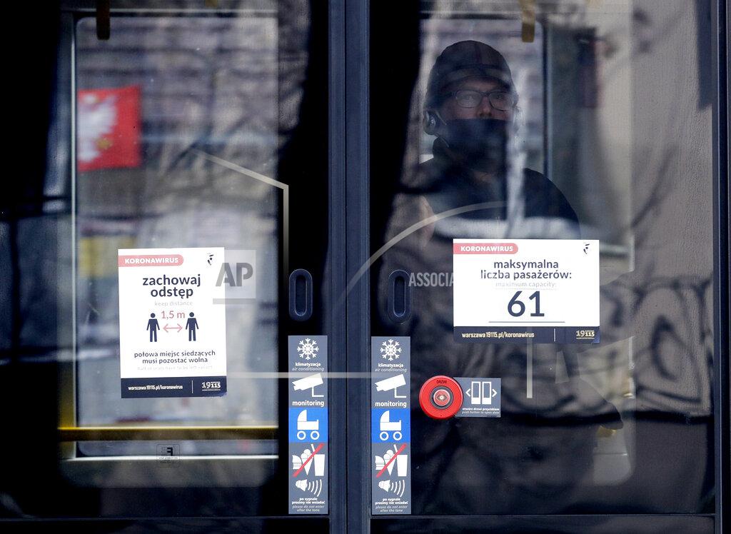 Czarek Sokolowski A man stands by a tram door with a sign informing no more than 61 passengers can be inside due to the distancing measures against COVID-19, in Warsaw, Poland, on Thursday, March 25, 2021. Amid a sharp spike in new infections and hospitalizations that are bringing the health care to its limits, Poland has stepped up pandemic measures for two weeks starting Saturday, including fewer people to be allowed into churches at the holiday time.(AP Photo/Czarek Sokolowski)