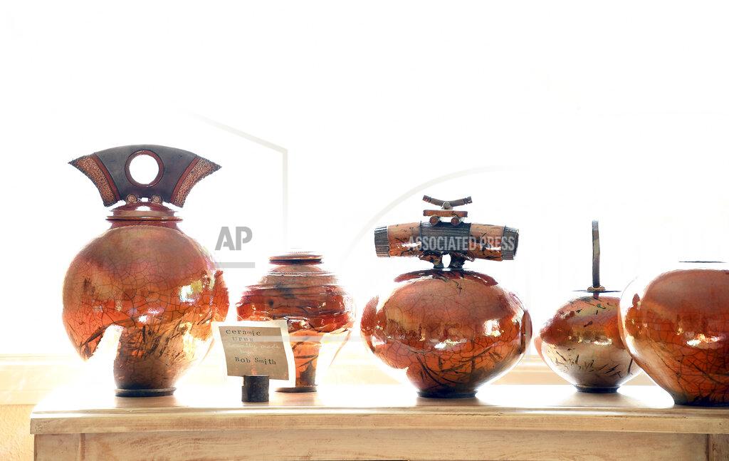 Thomas Peipert In this Friday, Aug. 27, 2021, photo, urns are displayed in a window at The Natural Funeral in Lafayette, Colo. The company is offering human body composting after Colorado became the second state after Washington to legalize the practice. (AP Photo/Thomas Peipert)