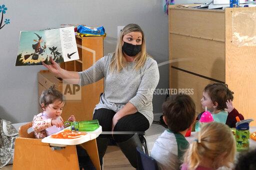 Amy McCoy reads a book to preschoolers as they finish their lunch at her Forever Young Daycare facility, Monday, Oct. 25, 2021, in Mountlake Terrace, Wash. Child care centers once operated under the promise that it would always be there when parents have to work. Now, each teacher resignation, coronavirus exposure, and day care center closure reveals an industry on the brink, with wide-reaching implications for an entire economy's workforce. (AP Photo/Elaine Thompson)