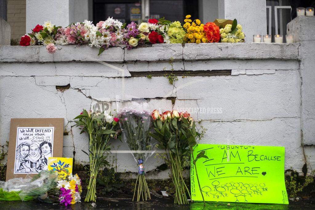 Alyssa Pointer Flowers and signs are displayed at a makeshift memorial outside of the Gold Spa in Atlanta, Wednesday, March 17, 2021. Police in the Atlanta suburb of Gwinnett County say they've begun extra patrols in and around Asian businesses there following the shooting at three massage parlors in the area that killed eight, most of them women of Asian descent. (Alyssa Pointer/Atlanta Journal-Constitution via AP)