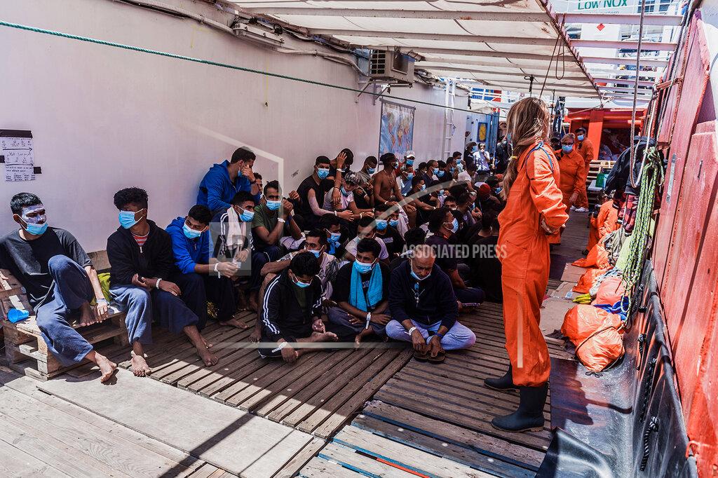 Flavio Gasperini Migrants sit on the deck of the Ocean Viking ship in the Mediterranean Sea, Sunday, July 5, 2020. A humanitarian group says its rescue ship with 180 migrants stranded aboard for days has “finally” received instructions to sail to an Italian port, so its passengers can be disembarked. SOS Mediterranee in a tweet on Sunday also described “relief on the #Ocean Viking” when the ship's crew and passengers learned that the rescued migrants are to be disembarked at Porto Empedocle, Sicily, the next day. (Flavio Gasperini/SOS Mediterranee via AP)
