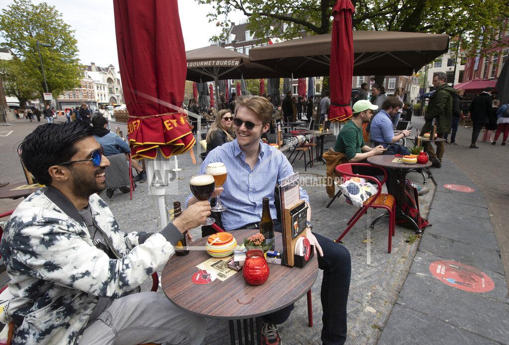 Peter Dejong FILE - In this Wednesday, April 28, 2021 file photo, people toast after terraces reopened at midday as the Netherlands became the latest European country to begin cautiously relaxing its lockdown, in Utrecht, Netherlands. Dutch zoos and theme parks will be allowed to re-open next week under strict conditions and bars and cafes can extend the opening hours of their outdoor terraces, if coronavirus infections and hospital admissions continue to fall, caretaker Prime Minister Mark Rutte announced Tuesday, May 11, 2021. .(AP Photo/Peter Dejong, file)