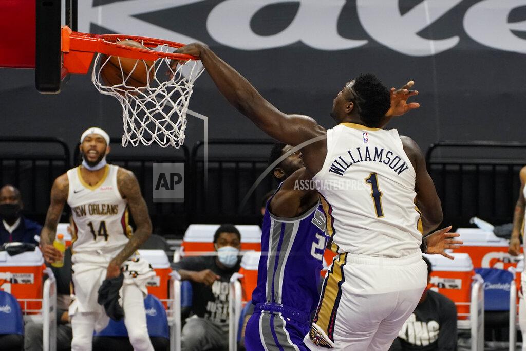 Rich Pedroncelli New Orleans Pelicans forward Zion Williamson, right, dunks over Sacramento Kings forward Chimezie Metu during the first quarter of an NBA basketball game in Sacramento, Calif., Sunday, Jan.17, 2021. (AP Photo/Rich Pedroncelli)