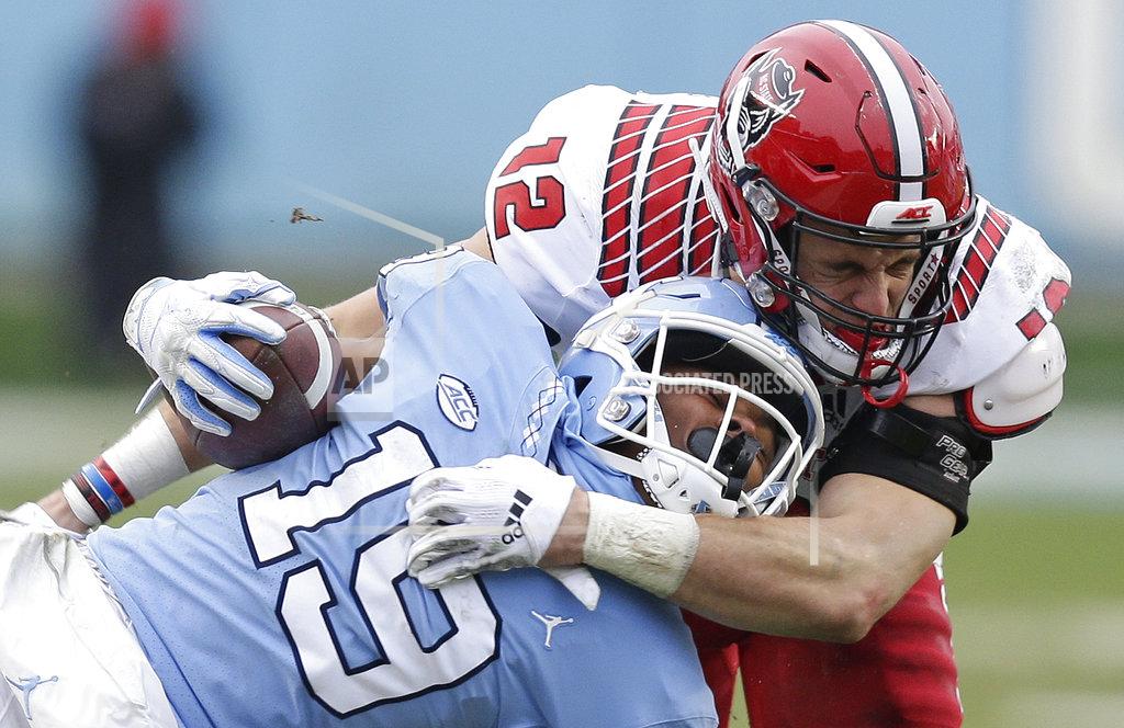 Gerry Broome North Carolina State's Brock Miller (12) tackles North Carolina's Dazz Newsome (19) during the first half of an NCAA college football game in Chapel Hill, N.C., Saturday, Nov. 24, 2018. (AP Photo/Gerry Broome)