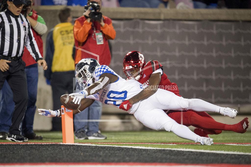 Bryan Woolston Kentucky running back Kavosiey Smoke (20) is tackled by Louisville safety Kaheem Roach (40) on a touchdown during the second half of the NCAA college football in Louisville, Ky., Saturday, Nov. 24, 2018. (AP Photo/Bryan Woolston)