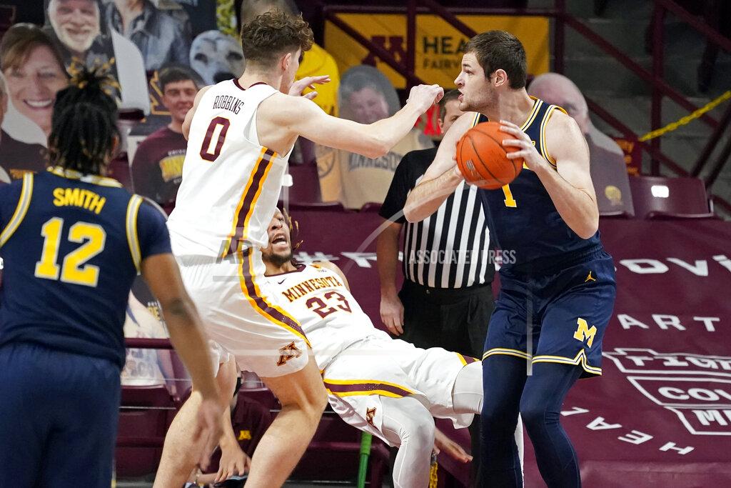 Jim Mone Minnesota's Brandon Johnson (23) falls as he defends against Michigan's Hunter Dickinson (1) during the first half an NCAA college basketball game, Saturday, Jan. 16, 2021, in Minneapolis. (AP Photo/Jim Mone)