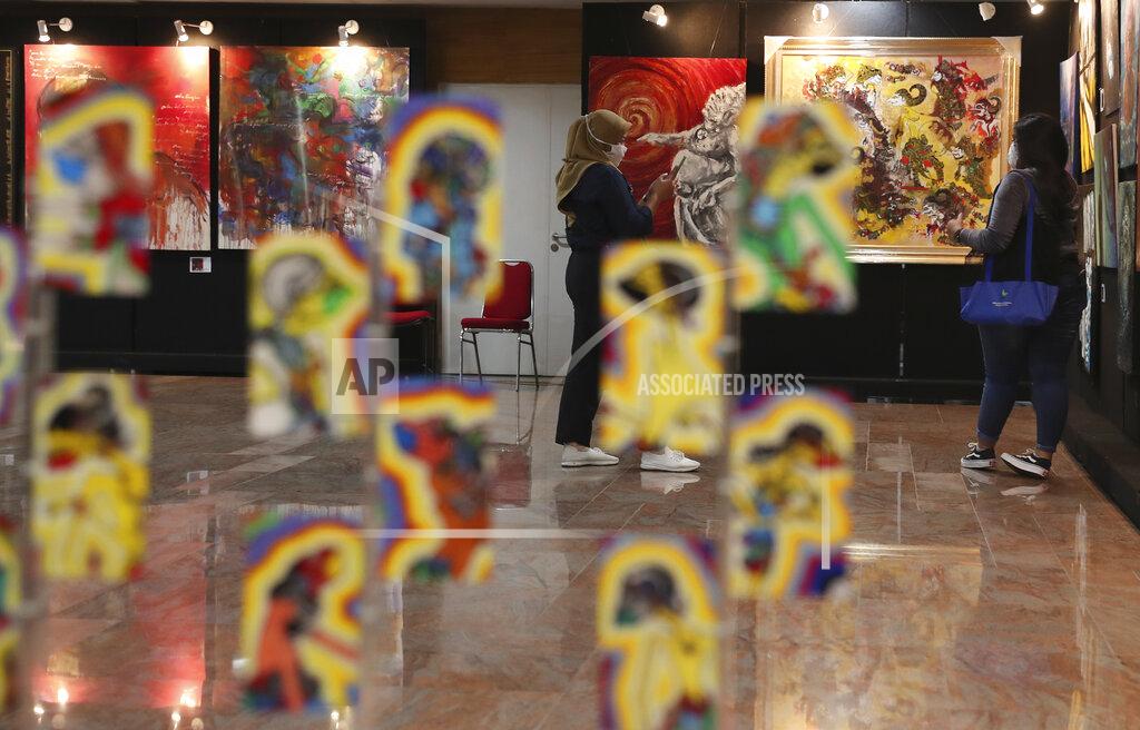 Achmad Ibrahim Indonesian women wearing face masks to help curb the spread of the coronavirus visit an art exhibition from Indonesian artists response to the pandemic in Jakarta, Indonesia, Thursday, Oct. 15, 2020. (AP Photo/Achmad Ibrahim)