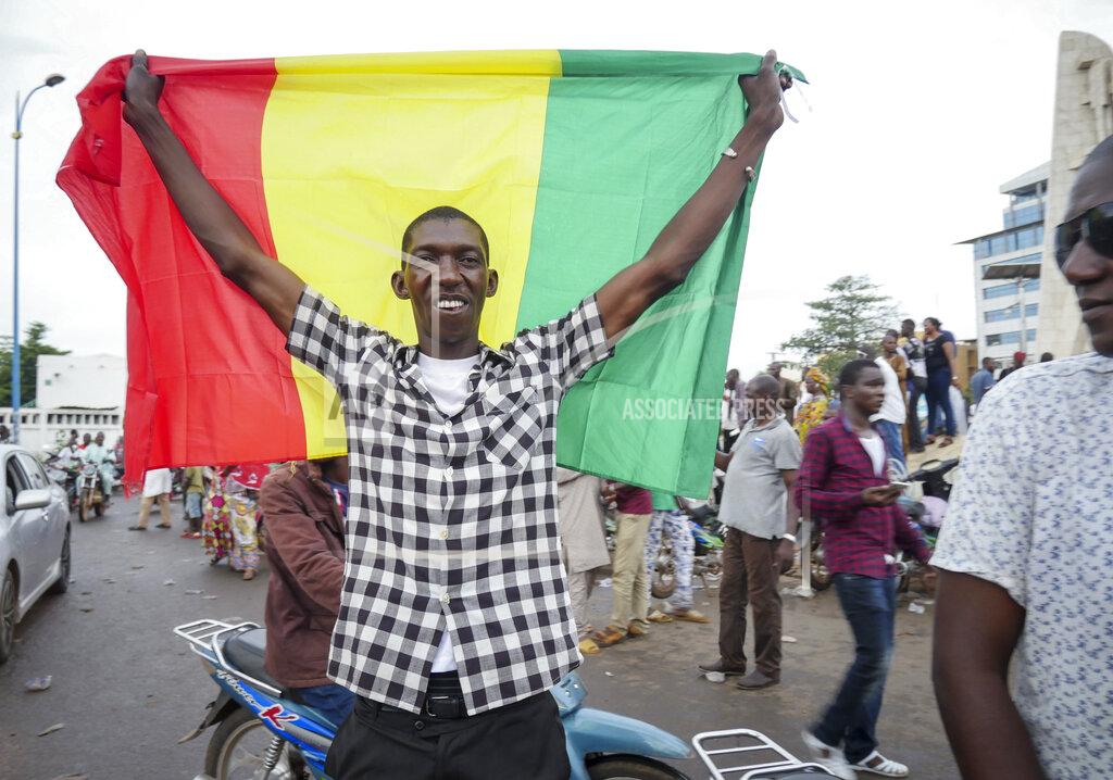 Uncredited A man holds a national flag as he celebrates with others in the streets in the capital Bamako, Mali Tuesday, Aug. 18, 2020. Mutinous soldiers detained Mali's president and prime minister Tuesday after surrounding a residence and firing into the air in an apparent coup attempt after several months of demonstrations calling for President Ibrahim Boubacar Keita's ouster. (AP Photo)