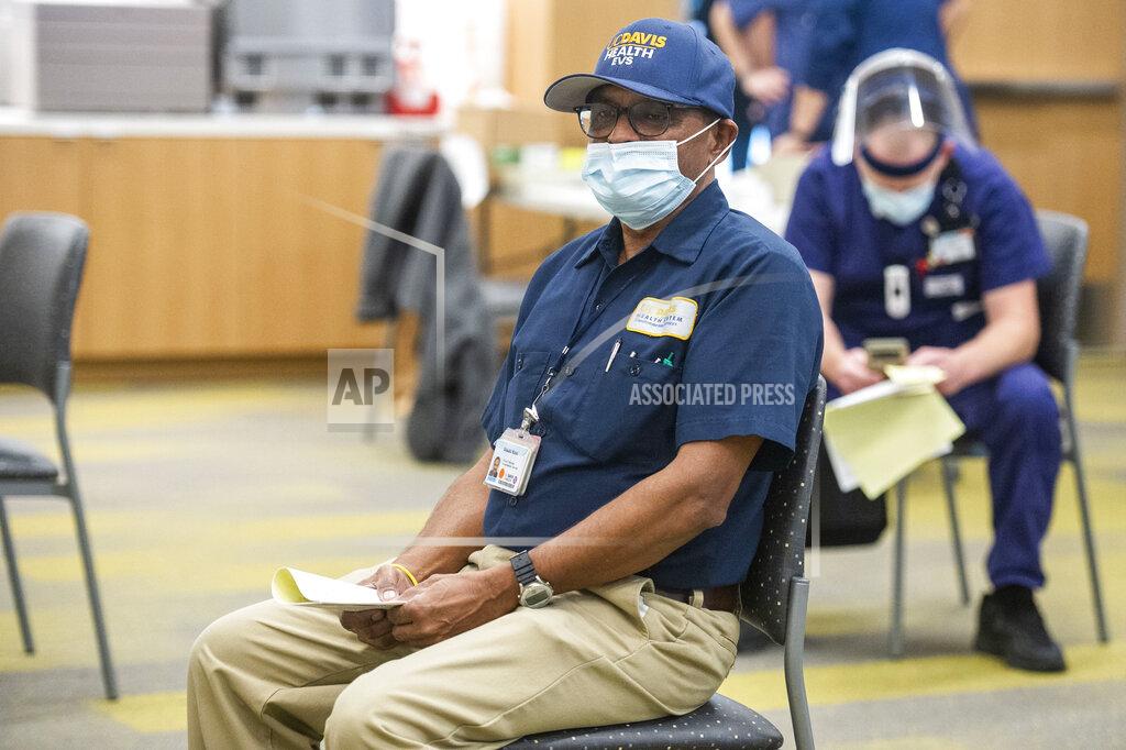 Hector Amezcua Shashi Kant, UC Davis Medical Center custodian, waits to be cleared after being inoculated with the Pfizer-BioNTech COVID-19 vaccine, Tuesday, Dec. 15, 2020 in Sacramento, Calif. (AP Photo/Hector Amezcua, Pool)