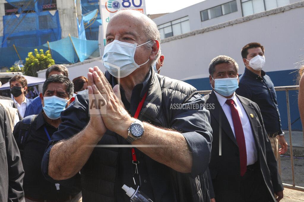 Martin Mejia Avanza Pais party presidential candidate Hernando De Soto, wearing a mask to curb the spread of the new coronavirus, waves to supporter upon his arrival to vote during general elections in Lima, Peru, Sunday, April 11, 2021. (AP Photo/Martin Mejia)