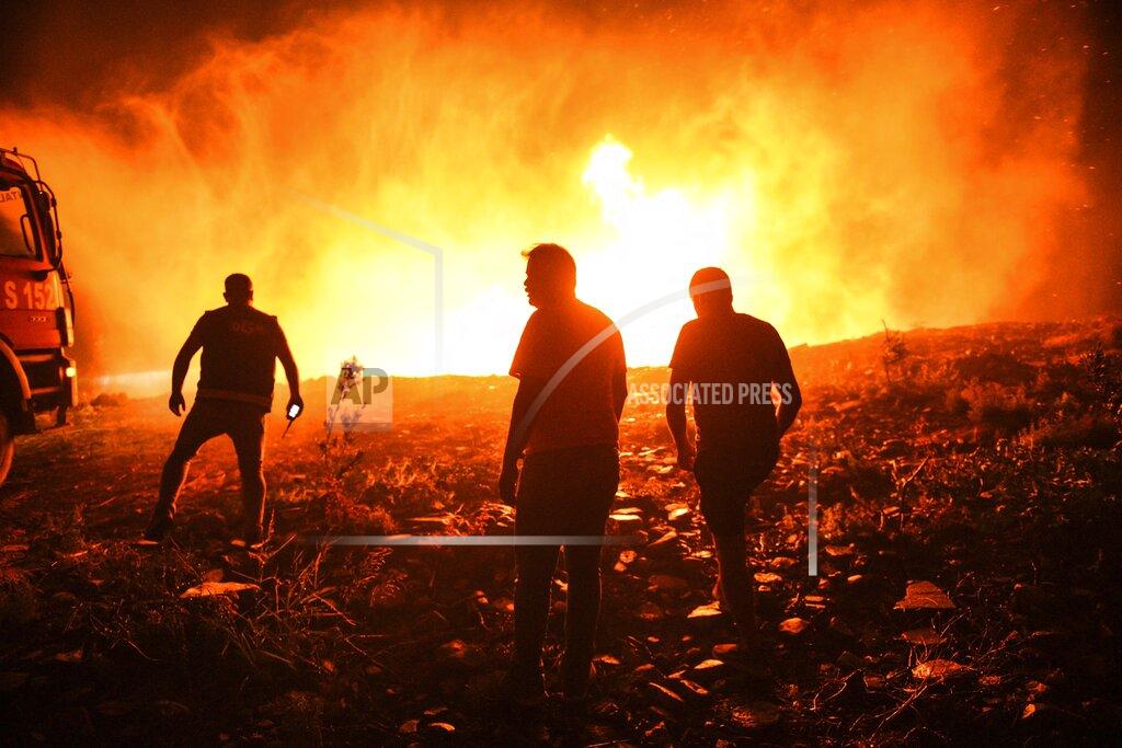 Uncredited Firefighters and Local villagers try to get the fire under control in Kirli village near the town of Manavgat, in Antalya province, Turkey, early Friday July 30, 2021. The fire that continued all night could not be brought under control and people living in the village started to evacuate. Wildfires are common in Turkey's Mediterranean and Aegean regions during the arid summer months, although some previous forest fires have been blamed on arson. (AP Photo)
