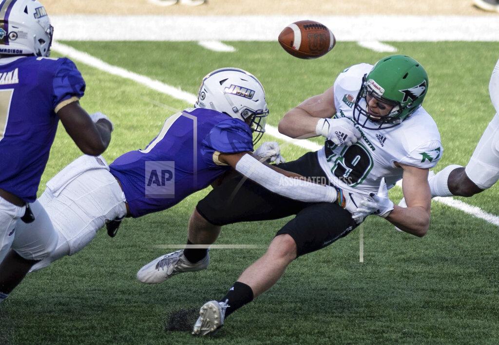 Daniel Lin James Madison safety Que Reid, left, forces a fumble by North Dakota tight end Adam Zavalney, right, during the first half of a quarterfinal game in the NCAA FCS football playoffs in Harrisonburg, Va., Sunday, May 2, 2021. (Daniel Lin/Daily News-Record via AP)
