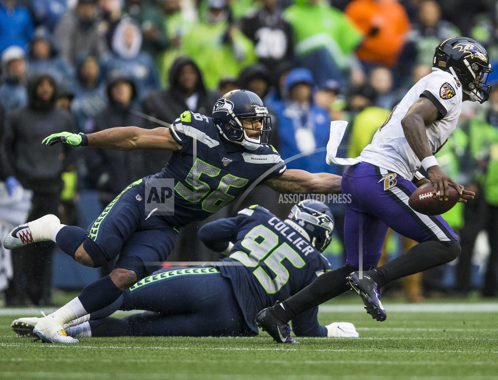 Olivia Vanni Seattle Seahawks' Mychal Kendricks (56) reaches to try and tackle Baltimore Ravens' Lamar Jackson, right, during an NFL football game Sunday, Oct. 20, 2019, in Seattle, Wash. (Olivia Vanni/The Herald via AP)