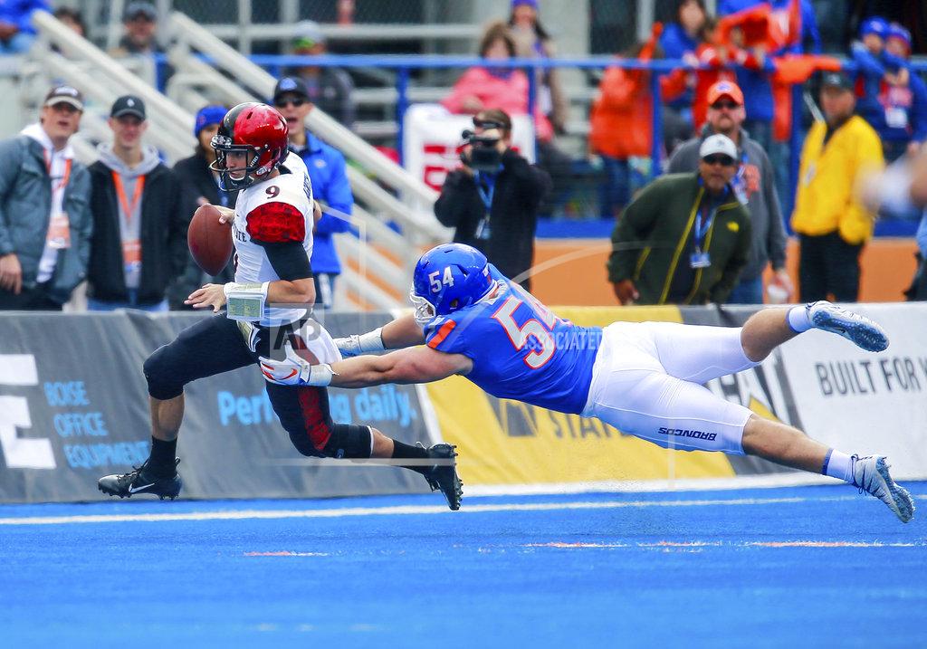Steve Conner San Diego State quarterback Ryan Agnew (9) runs from a tackle attempt by Boise State nose tackle Matt Locher (54) in the first half of an NCAA college football game, Saturday, Oct. 6, 2018, in Boise, Idaho. (AP Photo/Steve Conner)
