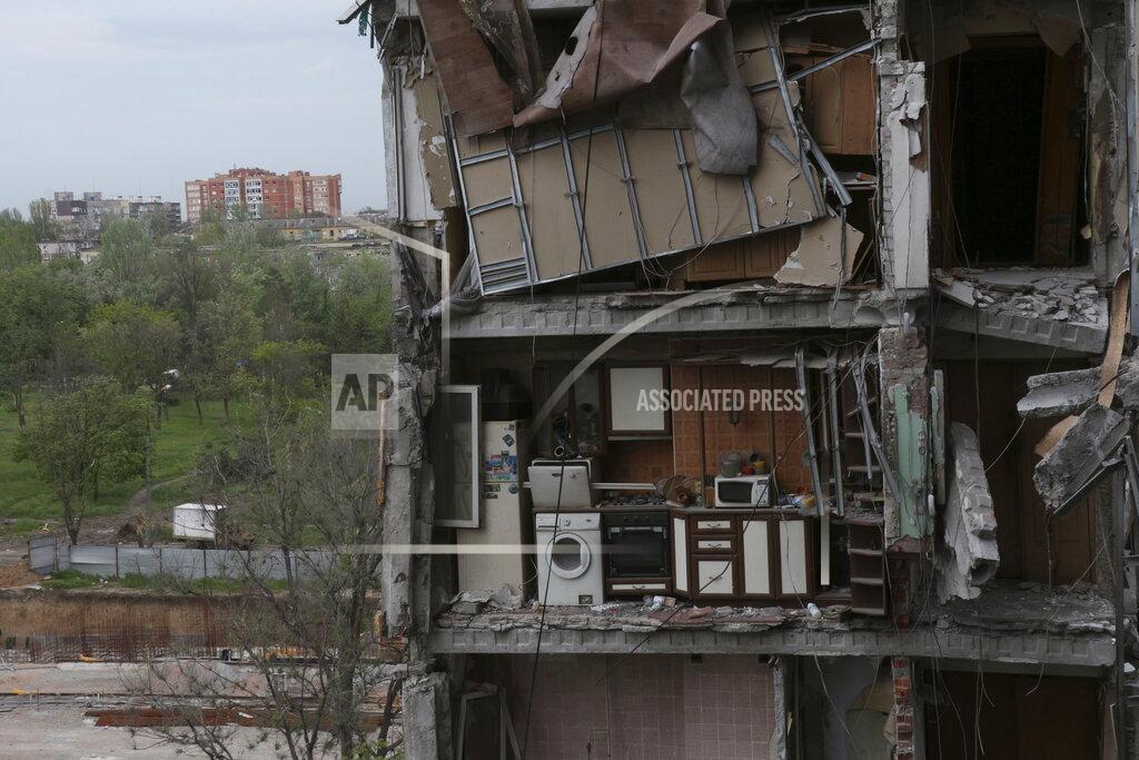 Uncredited CORRECTS DAY - A part of an apartment is seen at the side of damaged during a heavy fighting buildings in Mariupol, in territory under the government of the Donetsk People's Republic, eastern Ukraine, Friday, May 13, 2022. (AP Photo)