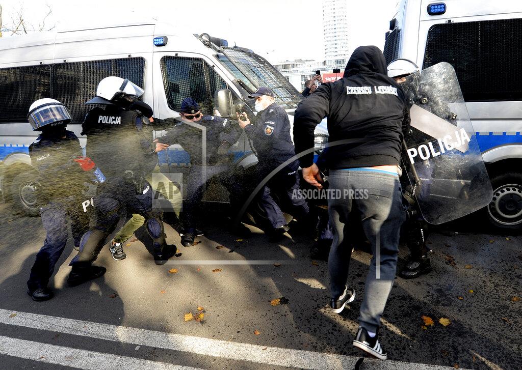 Czarek Sokolowski Polish police aim tear gas cannisters at protesters angry over new restrictions aimed at fighting the coronavirus pandemic, in Warsaw, Poland, Saturday, Oct. 24, 2020. The protesters included entrepreneurs, far-right politicians, football fans and vaccine opponents. The protesters, many wearing no protective masks, violated a new restriction on gatherings of more people. The clashes come amid rising social tensions and as new restrictions just short of a full lockdown took effect Saturday. (AP Photo/Czarek Sokolowski)