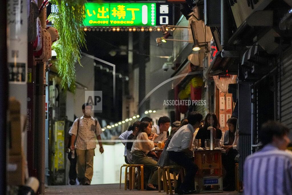 Kiichiro Sato People gather at bars that are open and serving alcohol on an ally filled with bars and restaurants despite Tokyo government has requested businesses not to serve alcohol under the state of emergency Wednesday, Sept. 22, 2021, in Tokyo. Japan is set on Tuesday, Sept. 28, 2021 to lift ongoing coronavirus state of emergency and less-stringent measures in all 27 prefectures including Tokyo when they expire at the end of September as the infections slow and the nation tries to reactivate its economy. (AP Photo/Kiichiro Sato)