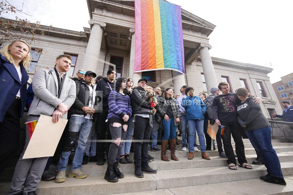 David Zalubowski Supporters of Club Q stand beneath a 25-foot historic pride flag displayed on the exterior of city hall to mark the weekend mass shooting at a gay nightclub Wednesday, Nov. 23, 2022, in Colorado Springs, Colo. (AP Photo/David Zalubowski)