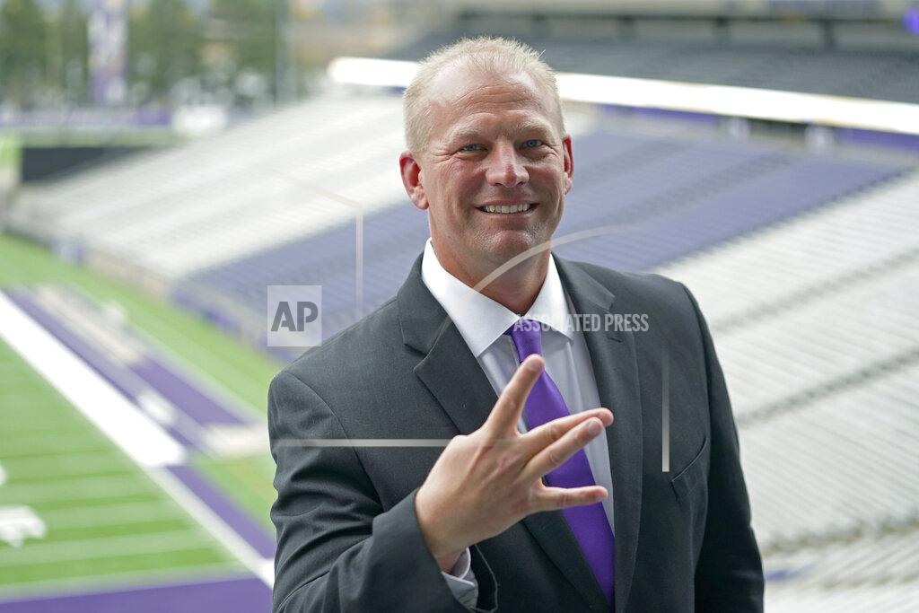 Ted S. Warren Kalen DeBoer flashes the Washington "W" hand sign as he poses for photos, Tuesday, Nov. 30, 2021, at Husky Stadium, following a news conference in Seattle to introduce him as the new head NCAA college football coach at the University of Washington. DeBoer has spent the past two seasons as head football coach at Fresno State. (AP Photo/Ted S. Warren)