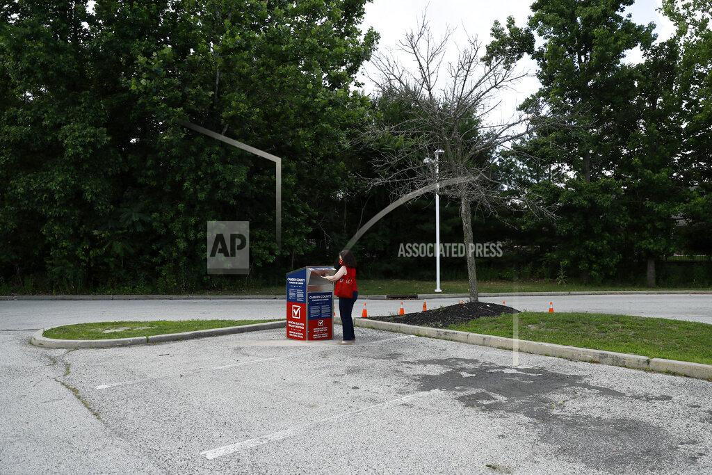 Matt Slocum FILE - In this July 1, 2020, file photo, Marianne Carver, of Pennsauken, N.J., drops off her ballot for the New Jersey primary election at a vote-by-mail drop box in a parking lot at Camden County College in Cherry Hill, N.J. The 2020 presidential election had all the makings of a looming disaster: fears of Russian meddling, violence at the polls, voter intimidation and poll workers fleeing their posts over the coronavirus. But the election was largely smooth, in large part because 107 million voters that cast their ballots early and took the pressure off Election Day operations. (AP Photo/Matt Slocum, File)