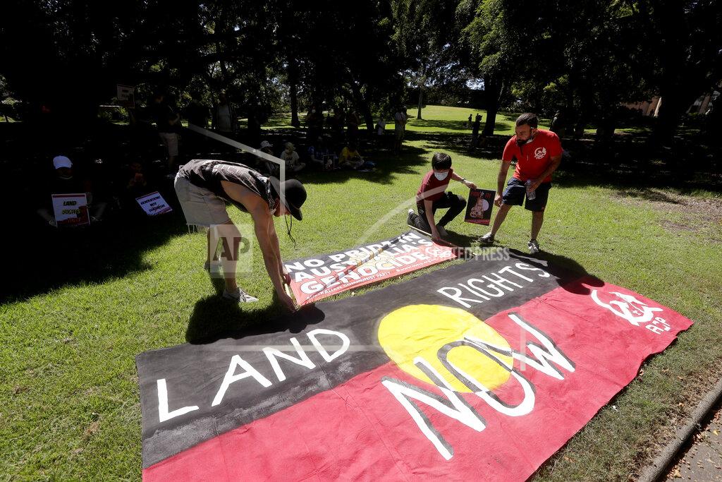 Rick Rycroft Protesters arrange signs in a social distanced crowd during an Aboriginal-lead Invasion Day rally on Australia Day in Sydney, Tuesday, Jan. 26, 2021. Many of Australia's First Nations people say that sovereignty has never been ceded and oppose ongoing colonial violence and destruction. (AP Photo/Rick Rycroft)