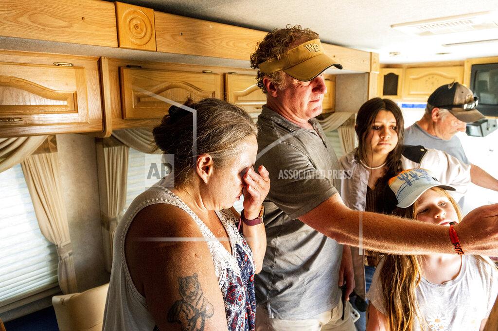 Noah Berger Kimberly Price wipes tears from her eyes while receiving a donated motorhome from EmergencyRV.org founder Woody Faircloth, center, on Sunday, Sept. 5, 2021, in Quincy, Calif. (AP Photo/Noah Berger)