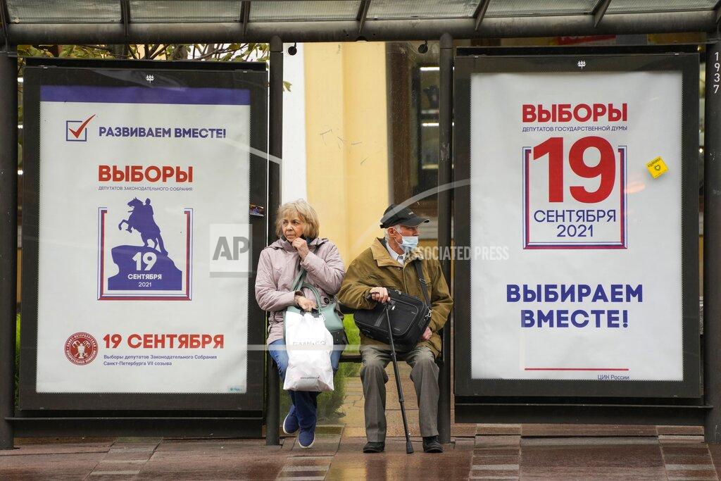 Dmitri Lovetsky FILE - In this Sept. 8, 2021, file photo, people sit at a bus stop decorated with posters ahead of the election to the State Duma, the lower house of parliament, and the local legislature in St. Petersburg, Russia. There will be three days of voting this weekend, ending on Sunday, Sept. 19, for the new parliament that is unlikely to change the country’s political complexion. (AP Photo/Dmitri Lovetsky, File)