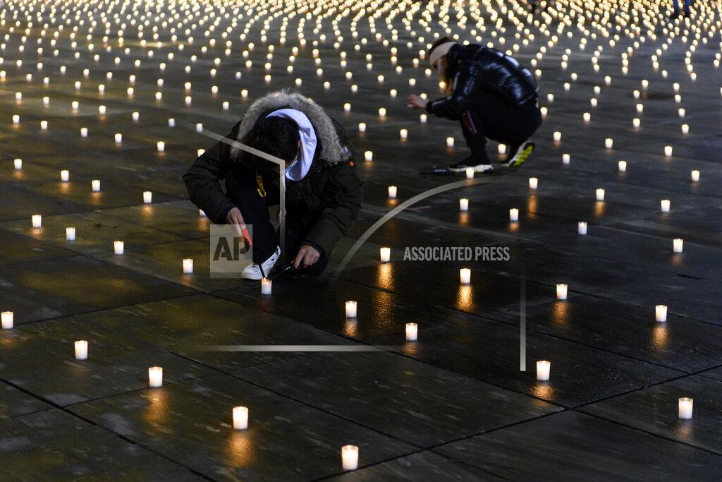 Anthony Anex Activists light about 5,000 candles to commemorate the people who died of the coronavirus in Switzerland, Sunday, Dec. 6, 2020, on the Bundesplatz, front of the Federal Palace, in Bern, Switzerland. (Anthony Anex/Keystone via AP)