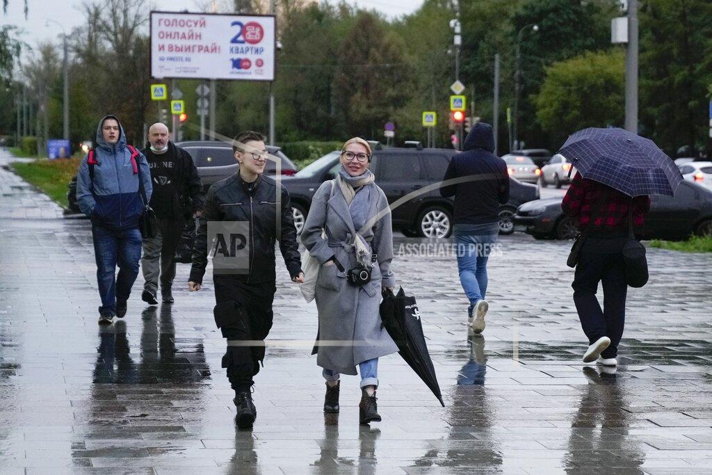 Pavel Golovkin Alyona Popova, the democratic Yabloko party candidate for the State Duma, center, walks in a street before a meeting with voters in Moscow, Russia, Friday, Sept. 3, 2021. Popova is running in a Moscow district, and her competitors include a famous TV personality widely seen as pro-government and a seasoned lawmaker from the Communist Party. (AP Photo/Pavel Golovkin)