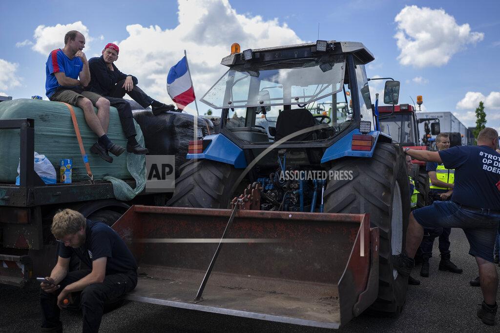 Peter Dejong Protesting farmers sit atop their vehicles at a blockade outside a distribution center for supermarket chain Aldi in the town of Drachten, northern Netherlands, Monday, July 4, 2022. Dutch farmers angry at government plans to slash emissions used tractors and trucks Monday to blockade supermarket distribution centers, the latest actions in a summer of discontent in the country's lucrative agricultural sector. (AP Photo/Peter Dejong)