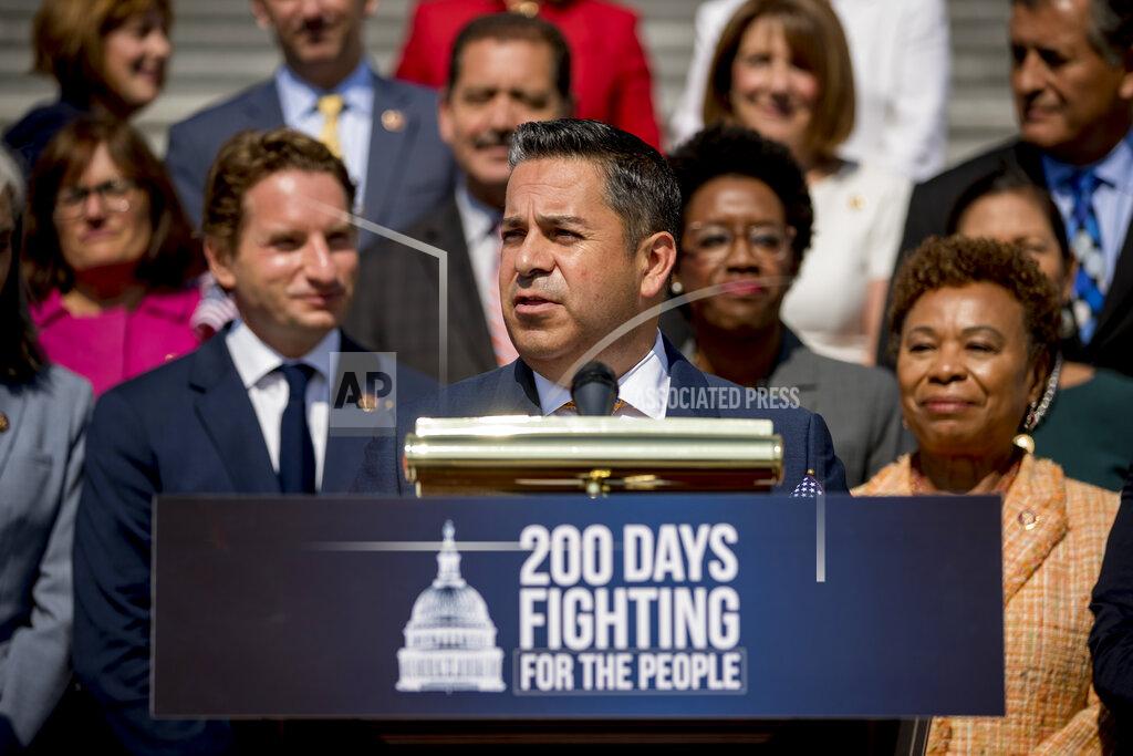 FILE - In this July 25, 2019, file photo, Rep. Ben Ray Lujan, center, D-N.M., speaks as House Democrats hold a news conference on the first 200 days of the 116th Congress, at the House East Front Steps of the Capitol in Washington. Lujan, the son of a legendary Latino political powerbroker, a political protégé of Nancy Pelosi and a former casino dealer, has never lost in election in seven contests for federal and state office. Lujan is vastly outspending well-known Republican former television meteorologist Mark Ronchetti, a first-time political candidate with a tough-on-crime message, in the race to succeed retiring Sen. Tom Udall. (AP Photo/Andrew Harnik, File)
