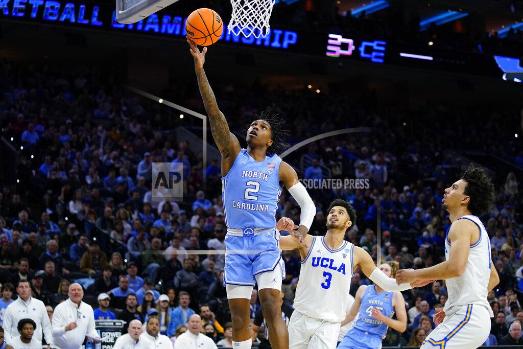 Matt Rourke North Carolina's Caleb Love (2) goes up for a shot past UCLA's Johnny Juzang (3) and Jules Bernard (1) during the second half of a college basketball game in the Sweet 16 round of the NCAA tournament, Friday, March 25, 2022, in Philadelphia. (AP Photo/Matt Rourke)