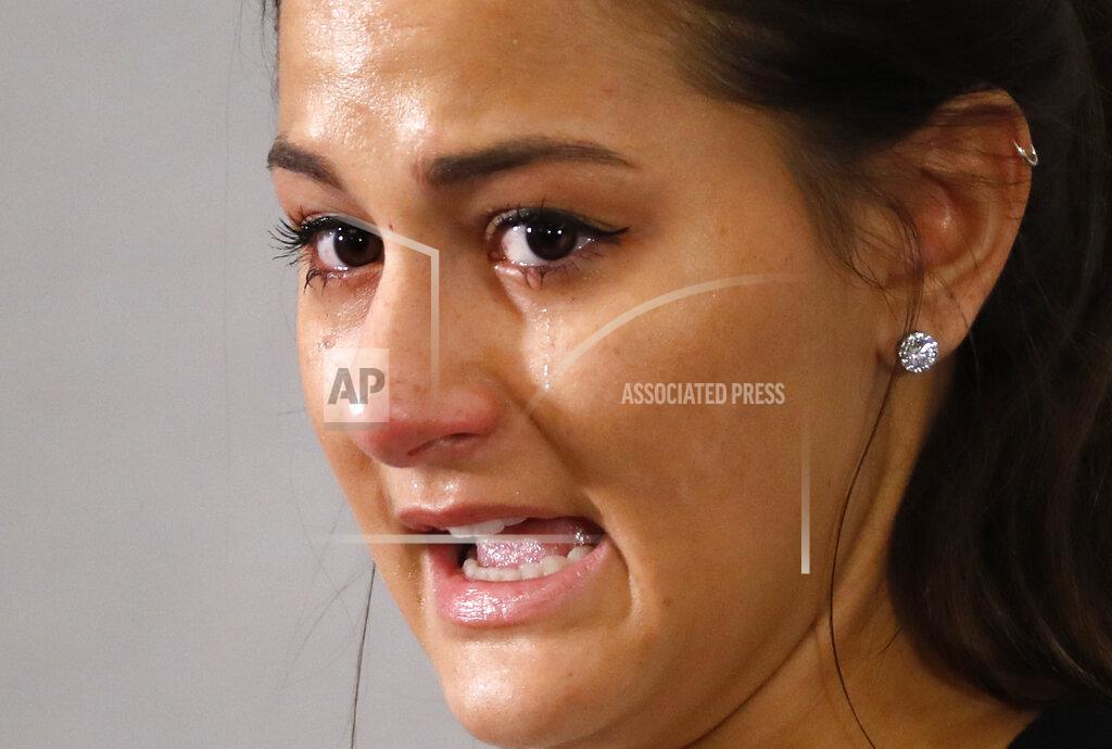 Paul Sancya Bailey Kowalski cries as she speaks during a news conference in East Lansing, Mich., Thursday, April 11, 2019. The 22-year-old Michigan State University student is speaking publicly a year after suing the school, alleging that three former men's basketball players raped her in 2015 and that she was discouraged by counseling center staff from reporting what happened. (AP Photo/Paul Sancya)