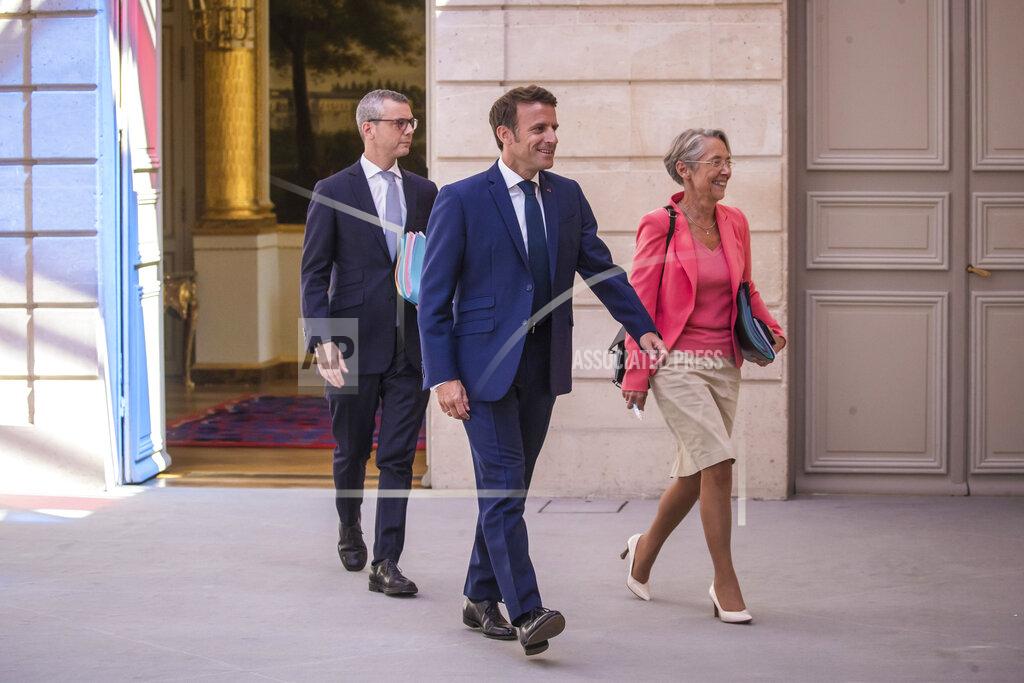 Christophe Petit Tesson French President Emmanuel Macron, center, and Prime Minister Elisabeth Borne, right, arrive to attend the first cabinet meeting with new ministers at the Elysee Palace in Paris, Monday, July 4, 2022. French President Emmanuel Macron rearranged his Cabinet on Monday in an attempt to adjust to a new political reality following legislative elections in which his centrist alliance failed to win a majority in the parliament. (Christophe Petit Tesson, Pool via AP)