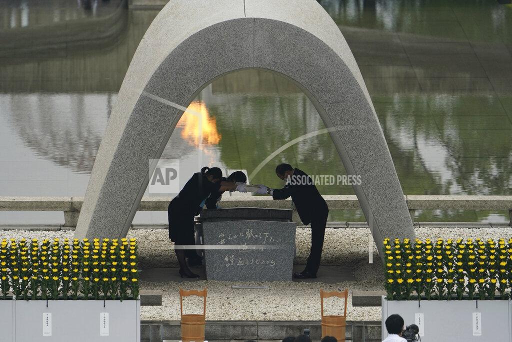 Eugene Hoshiko Kazumi Matsui, right, mayor of Hiroshima, and the family of the deceased bow before they place the victims list of the Atomic Bomb at Hiroshima Memorial Cenotaph during the ceremony to mark the 75th anniversary of the bombing at the Hiroshima Peace Memorial Park Thursday, Aug. 6, 2020, in Hiroshima, western Japan. (AP Photo/Eugene Hoshiko)