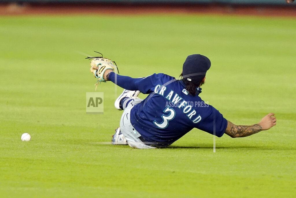 David J. Phillip Seattle Mariners shortstop J.P. Crawford slides while trying to catch a single by Houston Astros' Josh Reddick during the fifth inning of a baseball game Friday, Aug. 14, 2020, in Houston. (AP Photo/David J. Phillip)