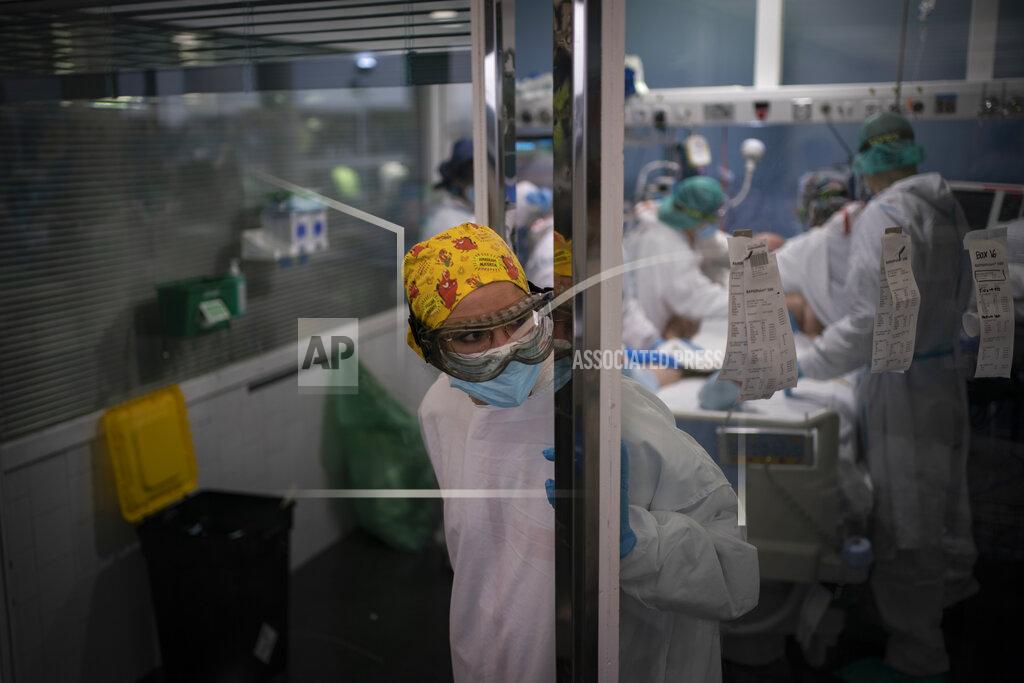 Felipe Dana In this Jan. 19, 2021 file photo, a health worker looks out from an ICU unit as a COVID-19 patient receives treatment in the Hospital del Mar, in Barcelona, Spain. The unrelenting increase in COVID-19 infections in Spain following the holiday season is again straining hospitals, threatening the mental health of doctors and nurses who have been at the forefront of the pandemic for nearly a year. (AP Photo/Felipe Dana)