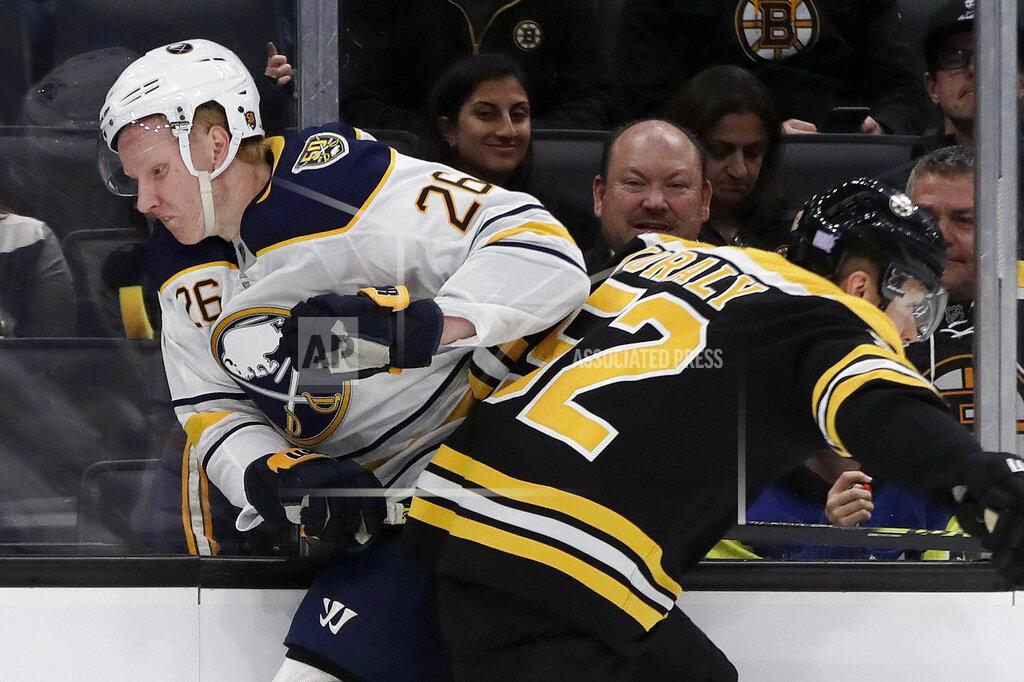 Buffalo Sabres defenseman Rasmus Dahlin (26) and Boston Bruins center Sean Kuraly (52) crash along the boards during the first period of an NHL hockey game Thursday, Nov. 21, 2019, in Boston. (AP Photo/Elise Amendola)