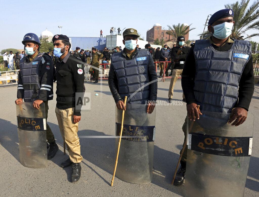 Asim Tanveer Pakistani police officers stand guard next to shipping containers blocking the path to a public park where the supporters of Pakistan Democratic Movement, an alliance of opposition parties, plan to hold an anti-government rally in Multan, Pakistan, Monday, Nov. 30, 2020. Pakistani police arrested hundreds of supporters of opposition parties ahead of a planned rally Monday calling for the country's prime minister to resign, a move the government defended as necessary to combat the coronavirus pandemic. (AP Photo/Asim Tanveer)