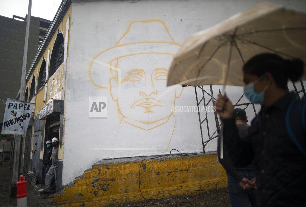 Ariana Cubillos A woman pass close to unfinished mural of Venezuelan popular saint, Dr. Jose Gregorio Hernandez, in Caracas, Venezuela, Wednesday, April 28, 2021. Known as the doctor of the poor, Hernandez is set to be beatified by the Catholic church, a step towards sainthood, on April 30th. (AP Photo/Ariana Cubillos)