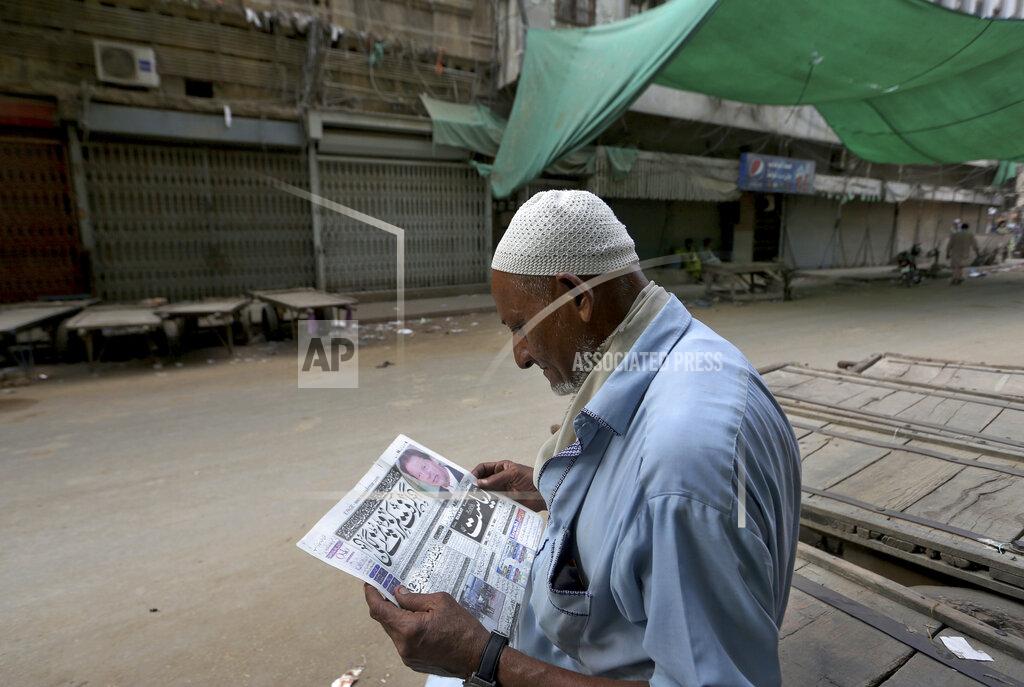Fareed Khan A man reads a copy of morning news paper at a market closed due to strikes called by the the country's religious political parties over the security forces's crackdown against a banned Tehreek-e-Labaik Pakistan party, in Karachi, Pakistan, Monday, April 19, 2021. An outlawed Pakistani Islamist political group freed 11 policemen almost a day after taking them hostage in the eastern city of Lahore amid violent clashes with security forces, the country's interior minister said Monday. (AP Photo/Fareed Khan)